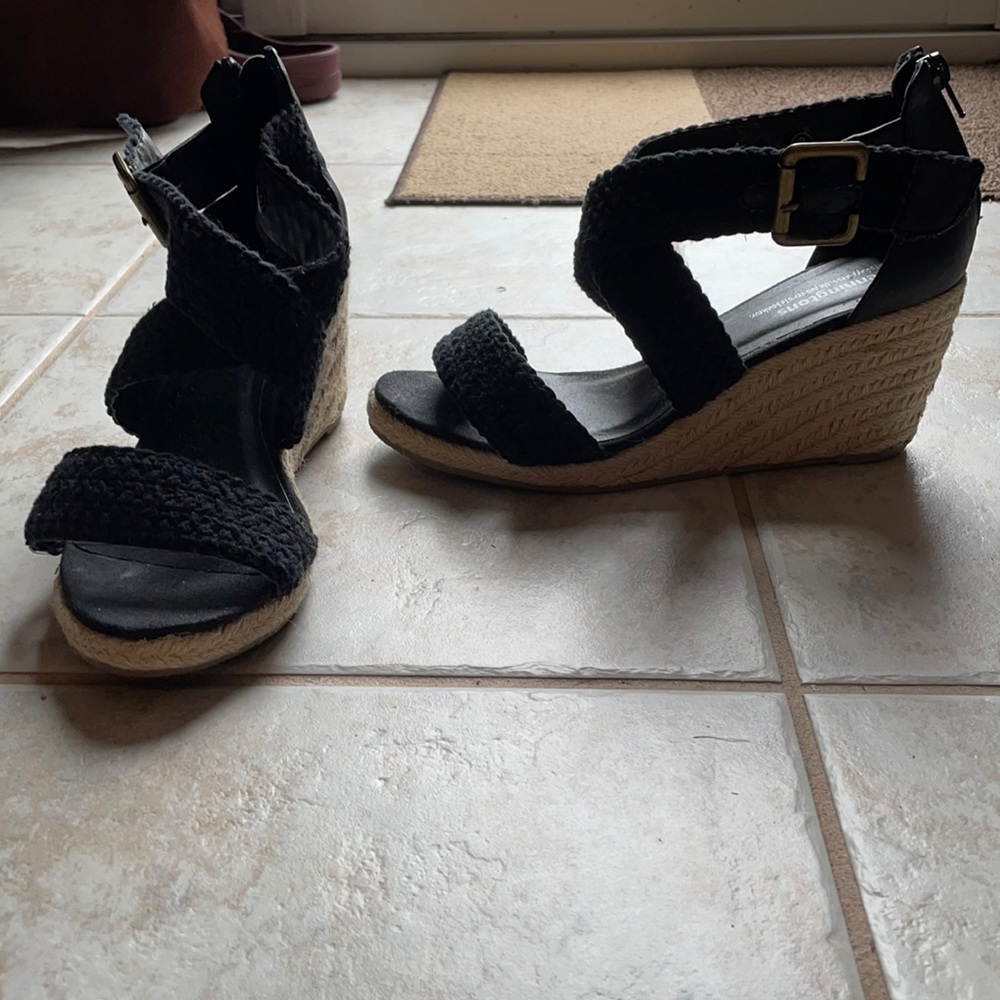 Black espadrilles with textured fabric detail and adjustable buckle.